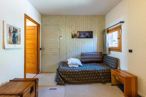 a room with a bed and a table and a door at Les arolles in Valloire