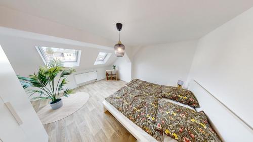 a bedroom with a bed and a potted plant at Dachgeschossromantik genießen, Bushaltestelle fußläufig erreichbar, WLAN in Chemnitz