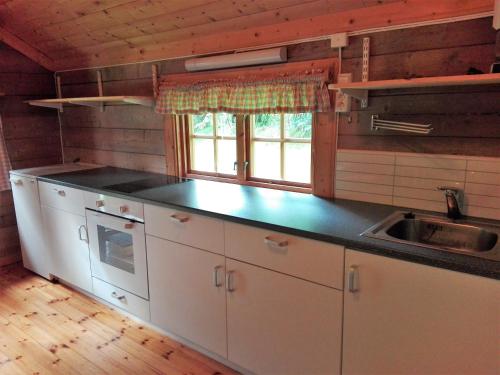 a kitchen with white cabinets and a counter top at Vårsetra in Bø