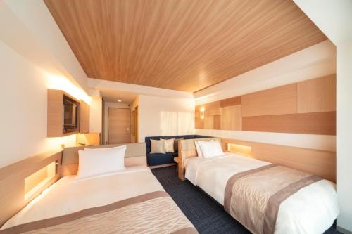 a hotel room with two beds in it at Izumigo AMBIENT Tateshina Hotel in Tateshina