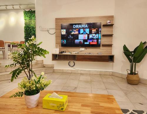 a living room with a flat screen tv on a wall at Amazing Petaling Jaya Corner Landed Home Paradigm Mall, 5 Bedroom for up to 18Pax, LDP, Kelana Jaya, Paradigm Mall in Petaling Jaya
