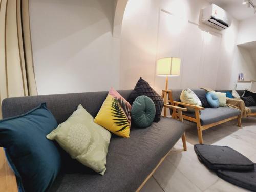 a living room with a couch with colorful pillows at Amazing Petaling Jaya Corner Landed Home Paradigm Mall, 5 Bedroom for up to 18Pax, LDP, Kelana Jaya, Paradigm Mall in Petaling Jaya