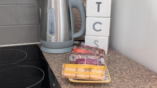 a counter top with some bread and a toaster at Captains Cottage in Scarborough