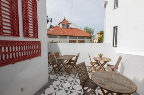 a patio with tables and chairs on a balcony at Casa de São Bento by PURUS in Coimbra