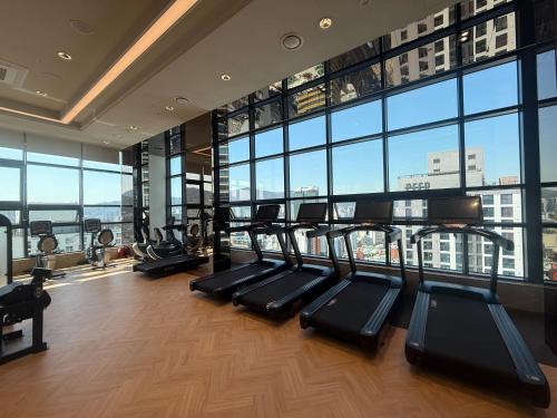 - une salle de sport avec une rangée de tapis de course dans un bâtiment dans l'établissement Sota Suite Busan Seomyeon, à Busan