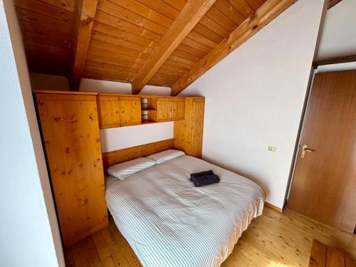 a bed in a small room with a wooden ceiling at Chalet Caldo & Accogliente a Cheggio "Obrigado House" in Alpe Cheggio