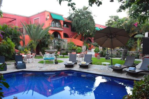 a pool with chairs and an umbrella next to a building at Collection O Casa Bella Hotel Boutique, Cabo San Lucas in Cabo San Lucas