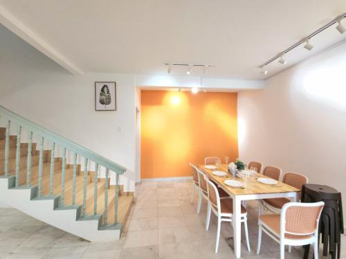 a dining room with a table and chairs and a staircase at Amazing Petaling Jaya Corner Landed Home Paradigm Mall, 5 Bedroom for up to 18Pax, LDP, Kelana Jaya, Paradigm Mall in Petaling Jaya