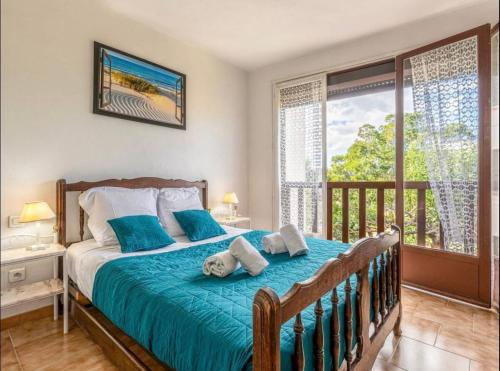 Cette chambre comprend un lit avec des draps bleus et un balcon. dans l'établissement Appartamentu Soli di Sud - St Cyprien, à Lecci