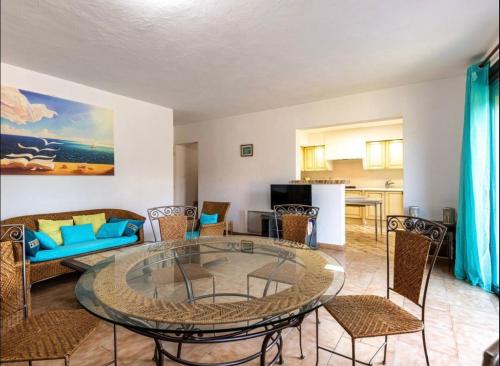 un salon avec une table en verre et des chaises dans l'établissement Appartamentu Soli di Sud - St Cyprien, à Lecci