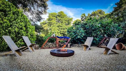 a fire pit with three chairs and a table and a fire at Casa Isabella - Villa mit Pool und Sauna in Pierle