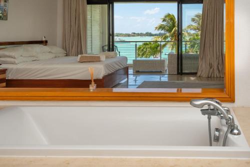 a bathroom with a bath tub with a view of a bedroom at 4- Bedroom Beachfront Villa in Grand Baie