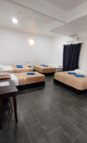 a room with four beds and a table in it at Perhentian Najmi Hotel in Perhentian Island