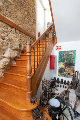 a wooden staircase in a room with a stone wall at Casa de São Bento by PURUS in Coimbra