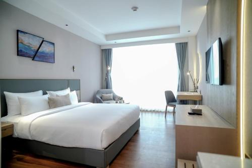 a bedroom with a large bed and a large window at Aurum by R J Resorts in Siliguri