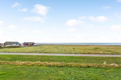 a house in the middle of a field with a road at Family Holiday With Sea View In Gedser Feriepark in Gedser
