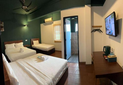 a bedroom with two beds and a television in it at Room V Kluang Parade By SECOM in Kluang