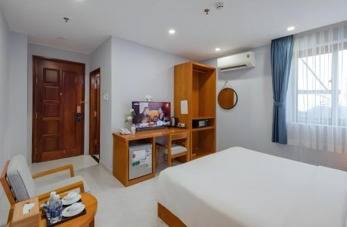 a bedroom with a bed and a chair and a desk at Stellar Phú Quốc - Hotel in Phu Quoc