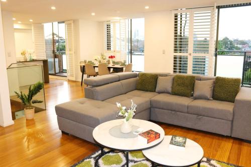 a living room with a couch and a table at Beautiful SYD Central 3Bedrooms Home with free Parking in Sydney