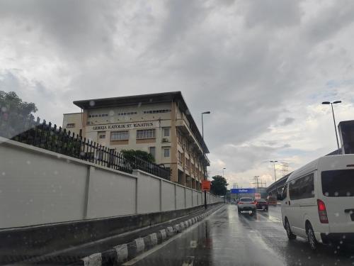 a white van driving down a street with a building at Amazing Petaling Jaya Corner Landed Home Paradigm Mall, 5 Bedroom for up to 18Pax, LDP, Kelana Jaya, Paradigm Mall in Petaling Jaya