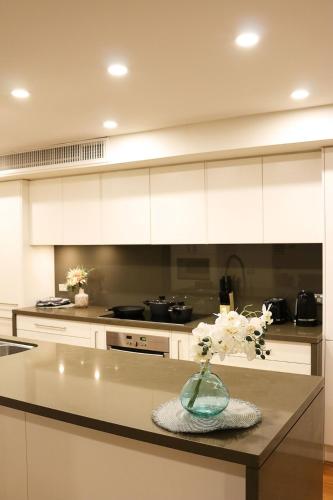a kitchen with a vase of flowers on a table at Beautiful SYD Central 3Bedrooms Home with free Parking in Sydney