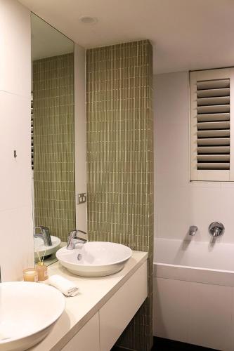 a bathroom with two sinks and a tub and a mirror at Beautiful SYD Central 3Bedrooms Home with free Parking in Sydney