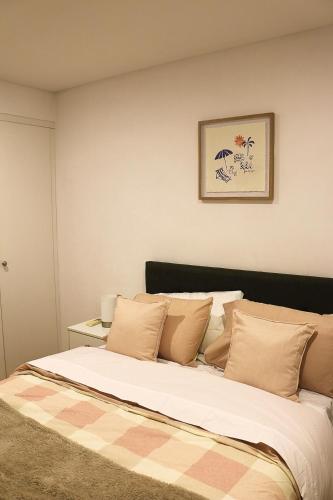 a bedroom with a large bed with pillows at Beautiful SYD Central 3Bedrooms Home with free Parking in Sydney