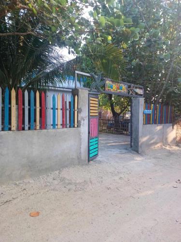 a gate with a colorful fence with surfboards at Homestay sao biển in Phương Phi
