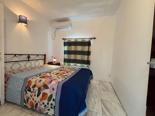a bedroom with a bed in a room with a window at Villas Floralies in Grand-Baie