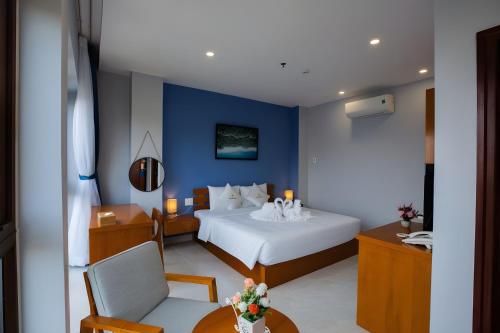 a bedroom with a white bed and a blue wall at Stellar Phú Quốc - Hotel in Phu Quoc