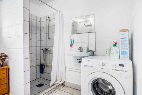 a washing machine in a bathroom with a shower at Holiday Home Near Water, Forest, And Møn's Cliffs in Stege