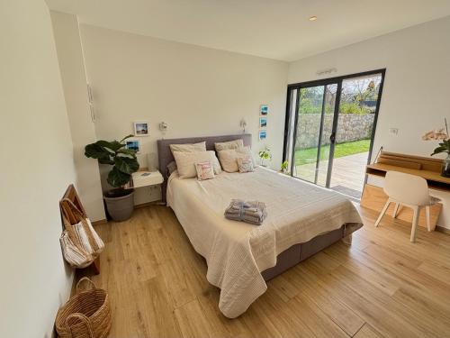 une chambre avec un lit et une grande fenêtre dans l'établissement L'essence du sud avec 4 suites, piscines et four à pizza, à Opio