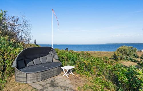a chair and a table on a hill next to the ocean at Awesome Home In Millinge With Sauna in Millinge