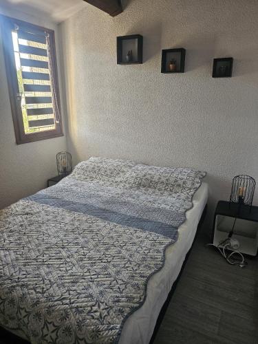 - une chambre avec un grand lit et une couette dans l'établissement Maison grande terrasse proche du port St Cyprien, à Saint-Cyprien