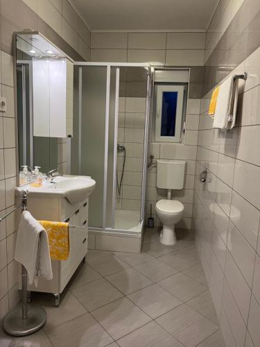 a bathroom with a toilet and a sink and a shower at Apartments Maria & Marta in Seline
