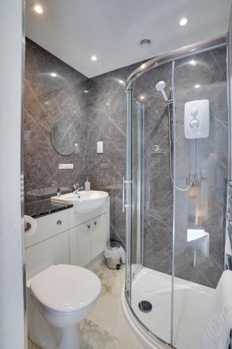 a bathroom with a shower and a toilet and a sink at The County Hotel - Self Check-In, Ultra Fast WI-FI, Free Parking, Central Location in Selkirk
