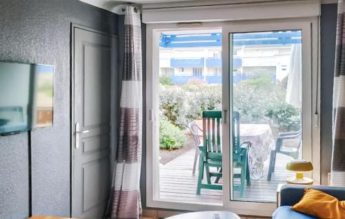 una porta scorrevole in vetro che conduce a un patio con tavolo di Pet-Friendly Apartment In Lacanau a Lacanau