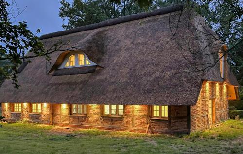 a house with a thatched roof with lights on at 3 Bedroom Stunning Home In Sittensen Kalbe in Kalbe