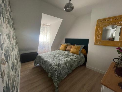 une chambre avec un lit et un miroir dans l'établissement L 'escale de st patern, à Vannes