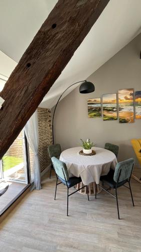 une salle à manger avec une table et des chaises blanches dans l'établissement L 'escale de st patern, à Vannes