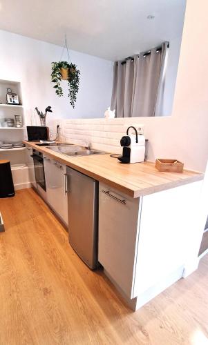 une cuisine avec un comptoir en bois dans une pièce dans l'établissement Les bons Enfants 9, à Rouen