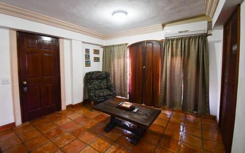 a living room with a table and a chair at Collection O Casa Bella Hotel Boutique, Cabo San Lucas in Cabo San Lucas