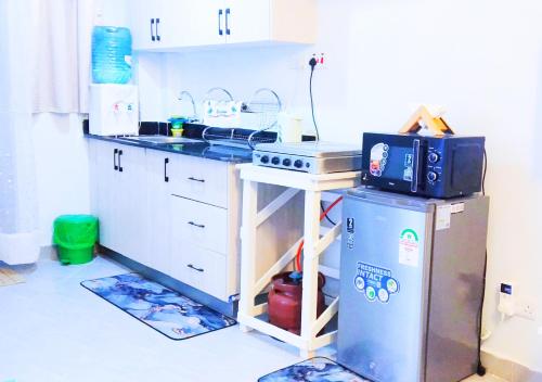 a kitchen with a stove and a refrigerator at Essik Homes Studio 2 - Muthiga, Waiyaki Way in Nairobi