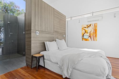 a bedroom with a large bed and a shower at Florida Beach House I Private Properties in Dawesville