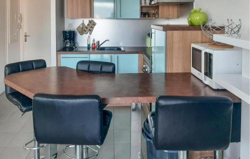 une cuisine avec une grande table et des chaises en bois dans l'établissement Stunning Apartment In Saint-Gilles-Croix-De-, à Le Sablais