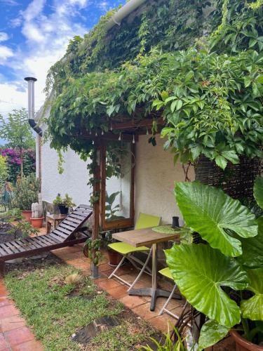 a patio with a table and a bench in front of a house at Sitges Garden Suite in Sitges
