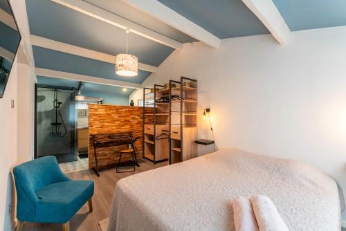 une chambre avec un lit et une chaise bleue dans l'établissement Les Dames De Molleges, à Mollégès