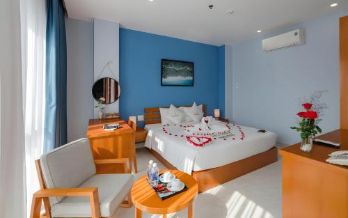 a bedroom with a white bed and a blue wall at Stellar Phú Quốc - Hotel in Phu Quoc