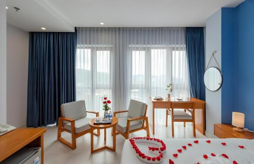 a bedroom with a bed and a table and chairs at Stellar Phú Quốc - Hotel in Phu Quoc