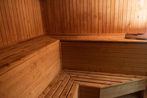 a wooden sauna with a wooden bench in it at Hoshen Hotel in Umanʼ